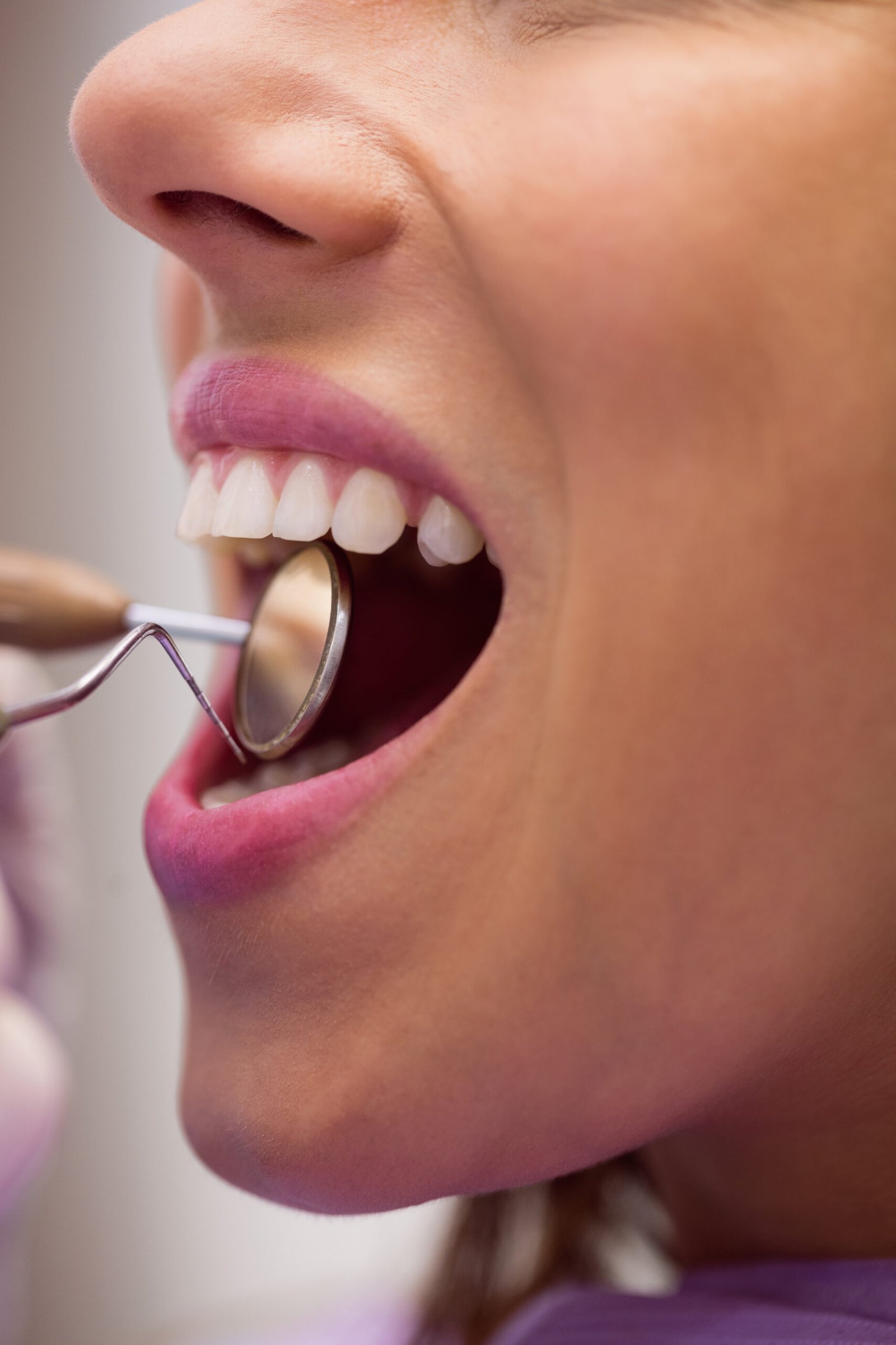 Home 7 Dentista analisando dentes com instrumento espelhado