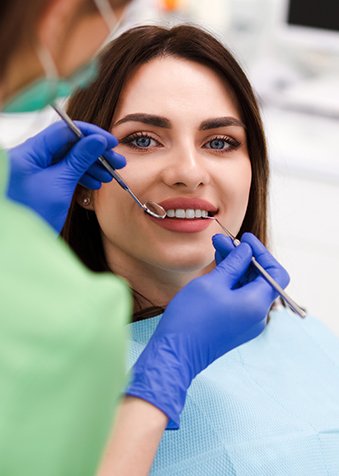 Coworking Odontológico 8 Mulher sorrindo enquanto dentista avalias seus dentes